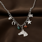 Silver necklace with various charms on a brown background