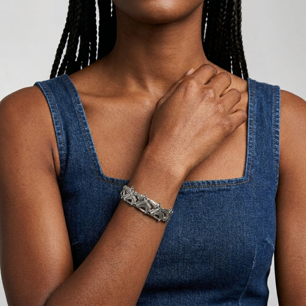 Woman wearing a silver racing horse bracelet on a plain background