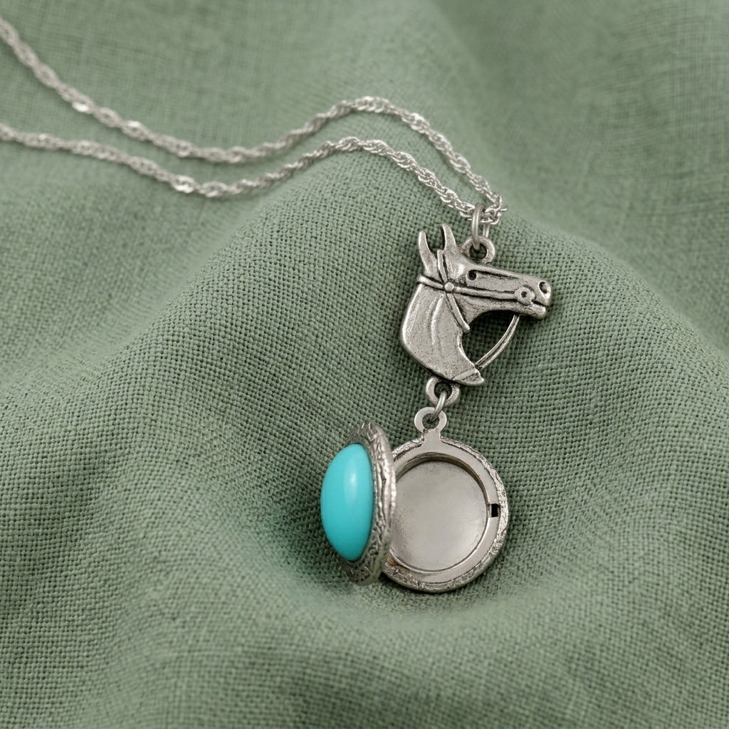 Necklace with a silver horse head pendant and turquoise stone on green fabric
