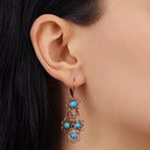 A close-up of a person's ear wearing a Desert Turquoise Stone Drop Earrings