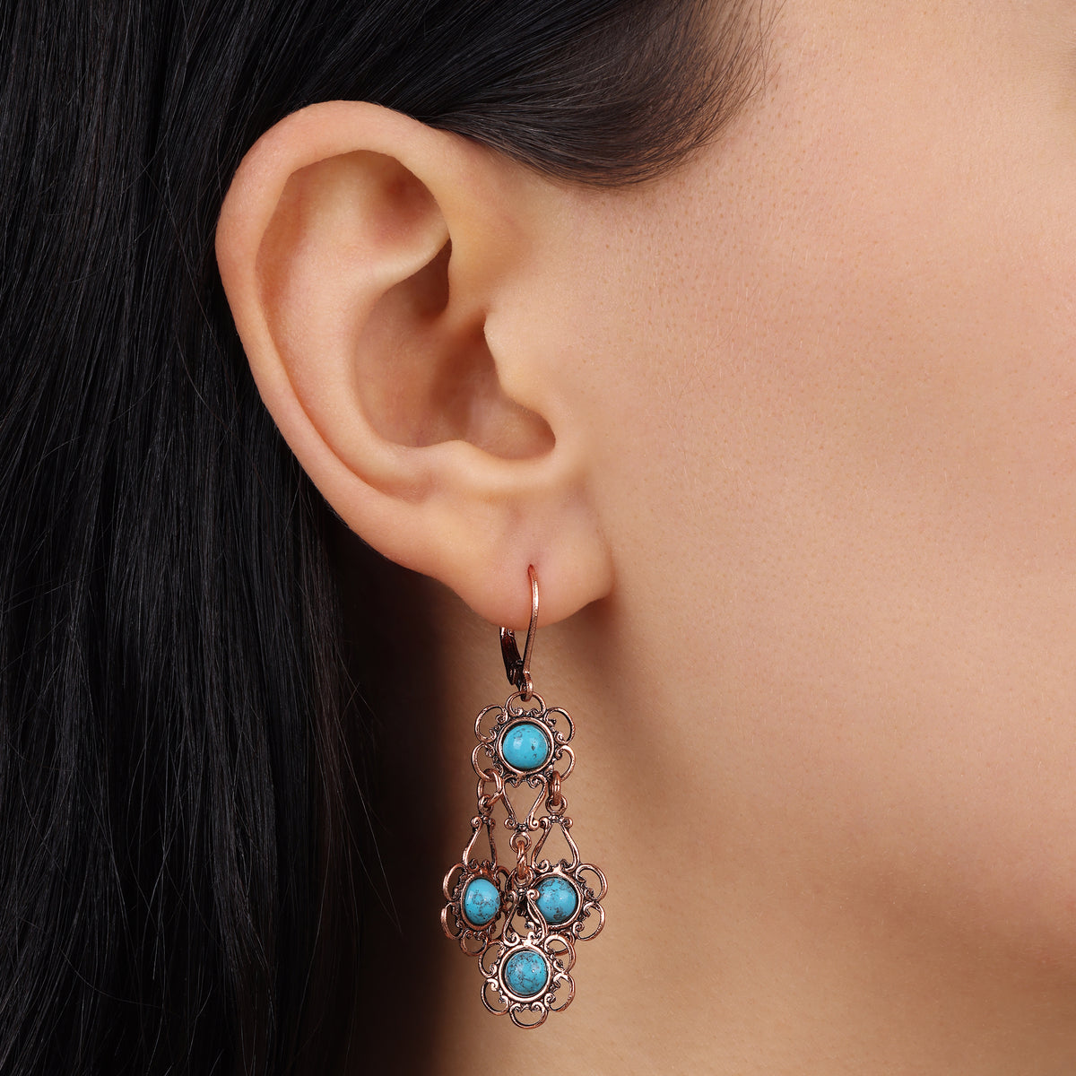 A close-up of a person's ear wearing a Desert Turquoise Stone Drop Earrings