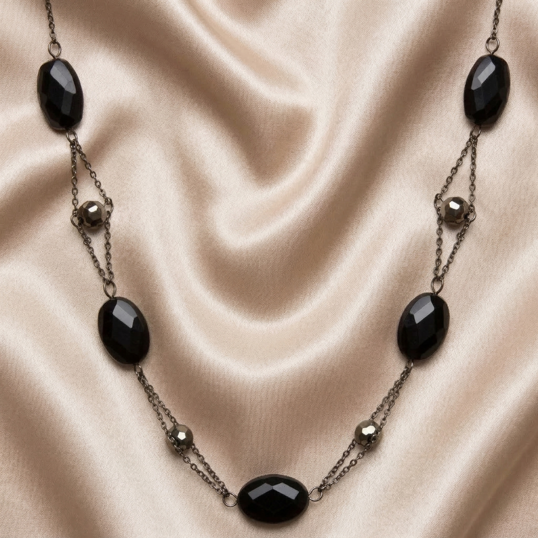 Necklace with black beads on a beige fabric background