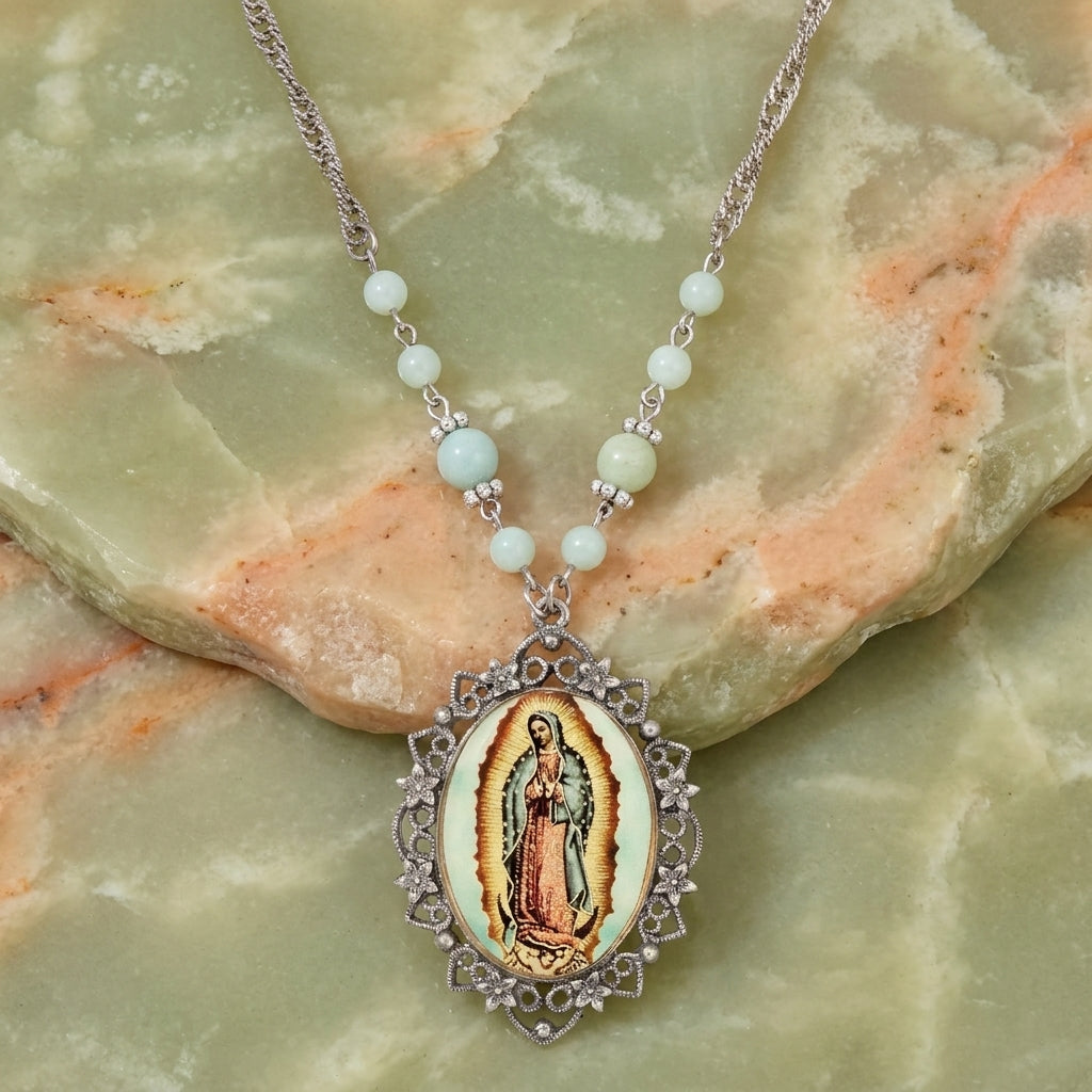 Necklace with a pendant featuring a religious icon Our Lady of Guadalupe on a green stone surface
