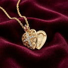 Gold heart-shaped locket with intricate designs on a burgundy fabric background