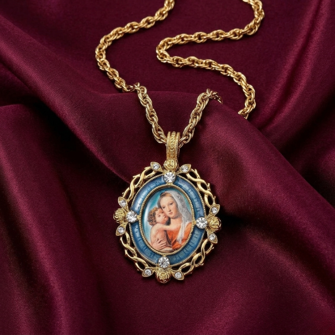 Gold necklace with a pendant featuring an image of a Mother Mary and Child on a maroon fabric background