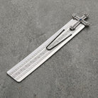 Silver bookmark with cross and floral design on a gray surface