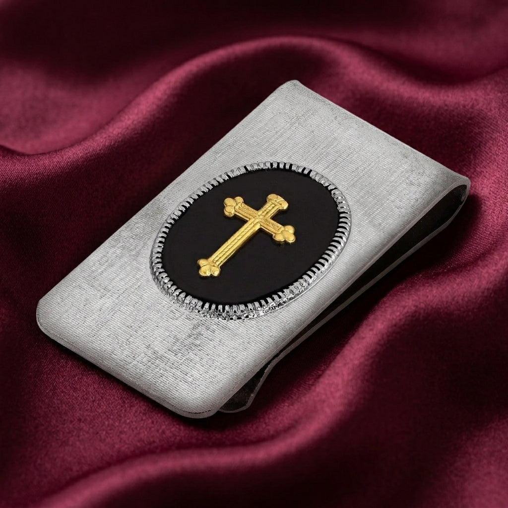 Silver money clip with a golden cross placed on burgundy colored satin fabric
