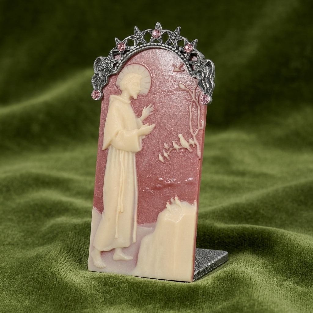 Decorative plaque with Saint Francis and decorative elements on a green fabric background