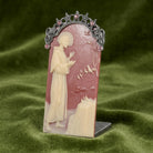 Decorative plaque with Saint Francis and decorative elements on a green fabric background