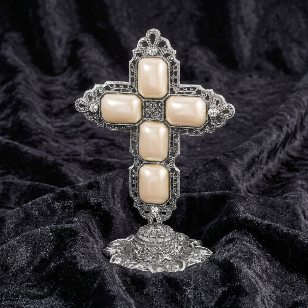 Decorative cross tabletop stand with gemstones on a black textured fabric background