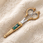 Crystal Cross and Green Enamel Scissor Holder With Scissors, photographed on cream lace fabric.