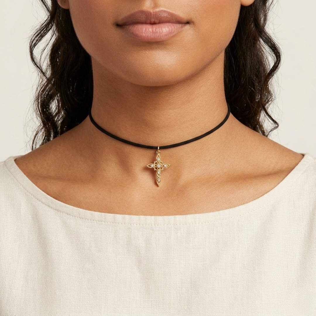Close-up of a person wearing a black choker with a gold pendant on a plain background
