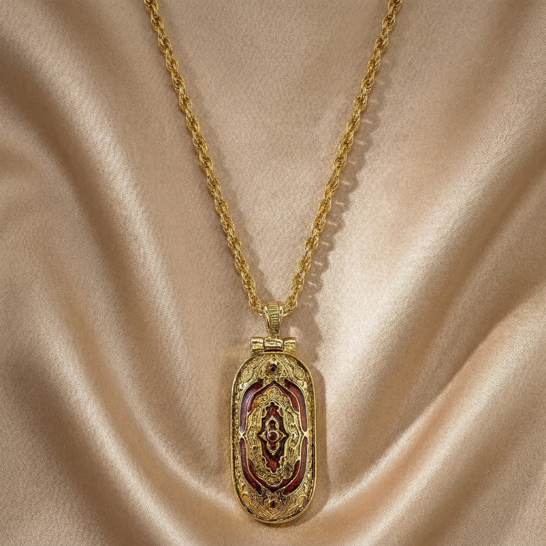 Gold necklace with an ornate pendant on a beige fabric background