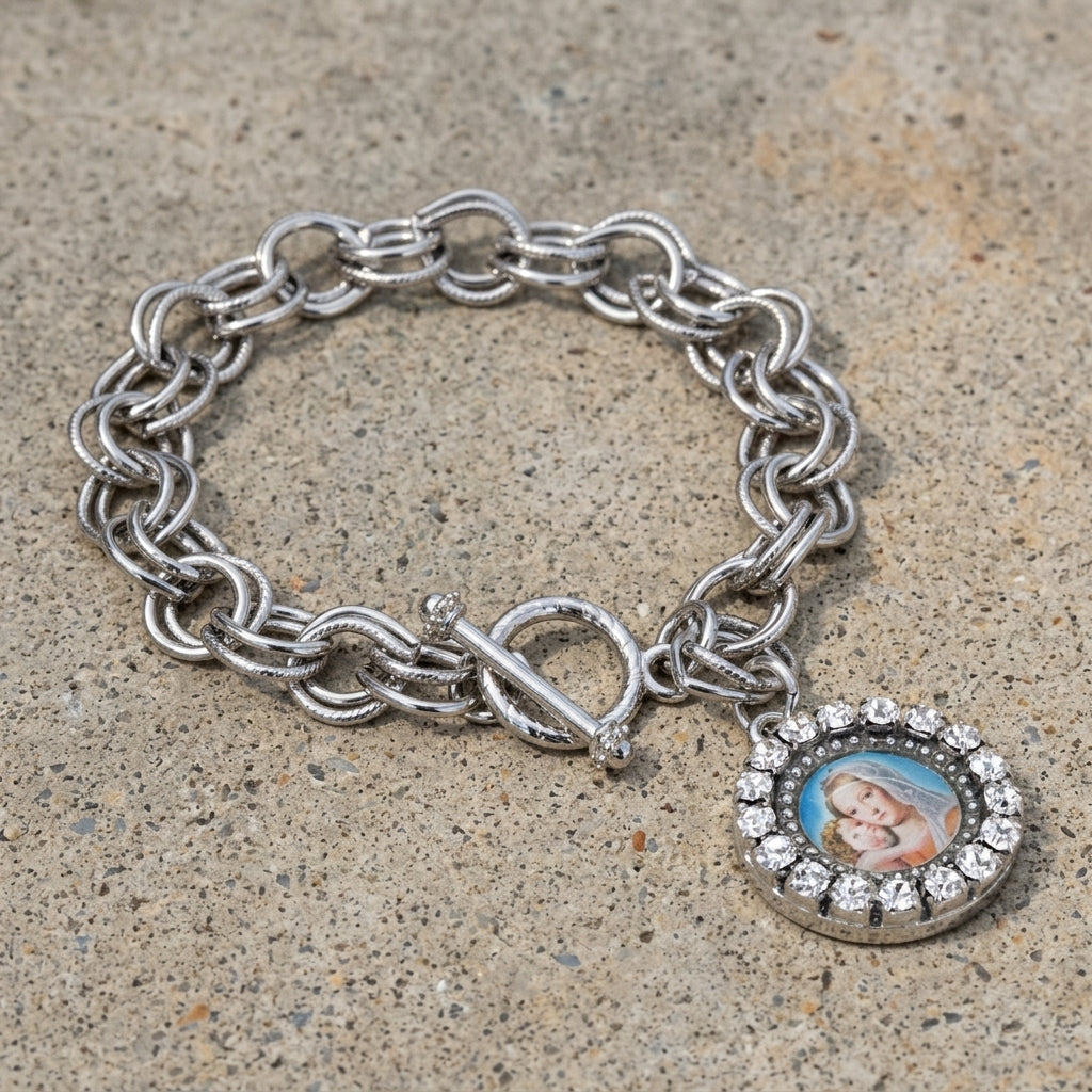 Mother Mary and Child silver tone toggle chain bracelet with clear crystal accents resting on a granite stone surface
