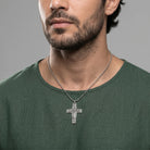Man wearing a silver tone cross necklace