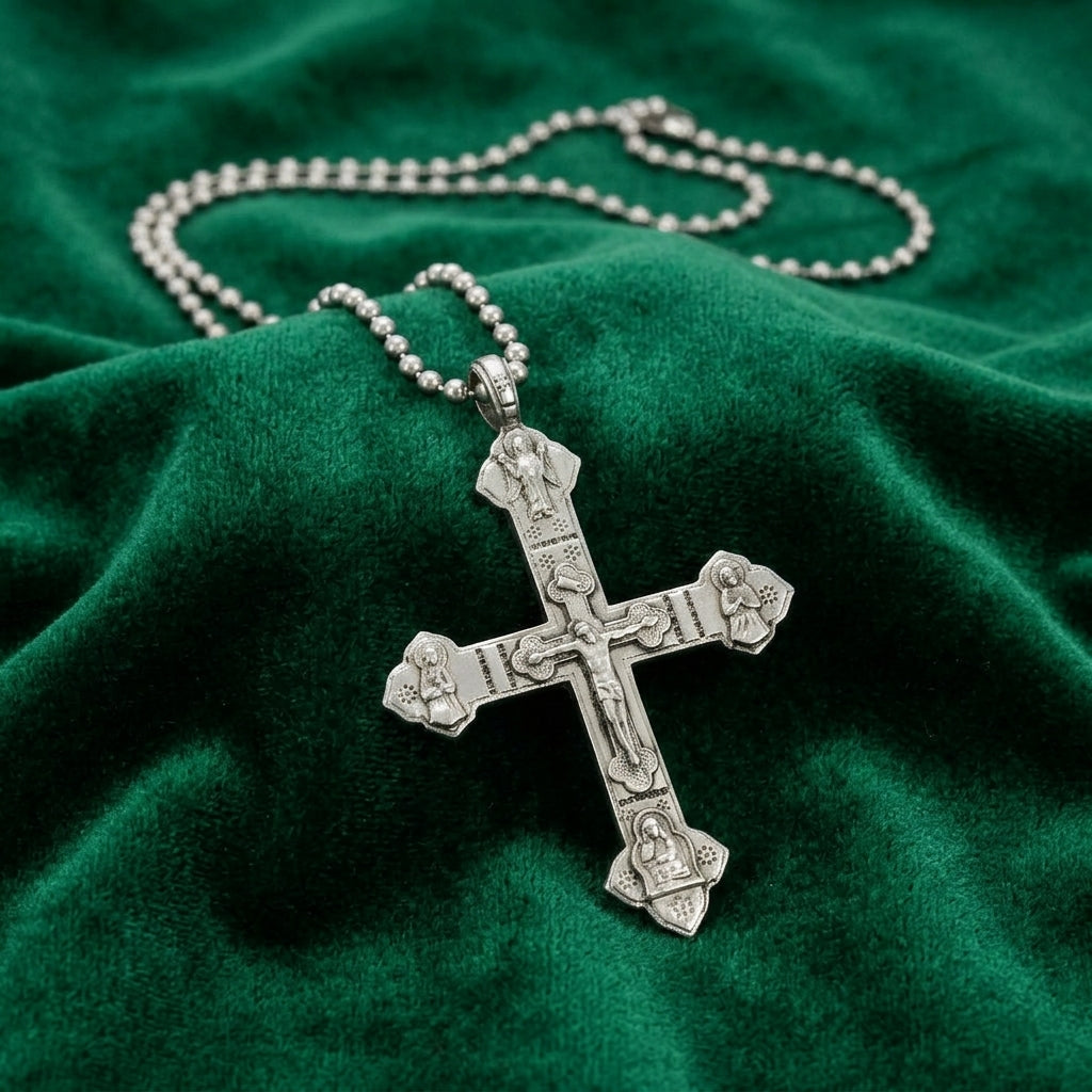 Silver crucifix pendant necklace on a green fabric background