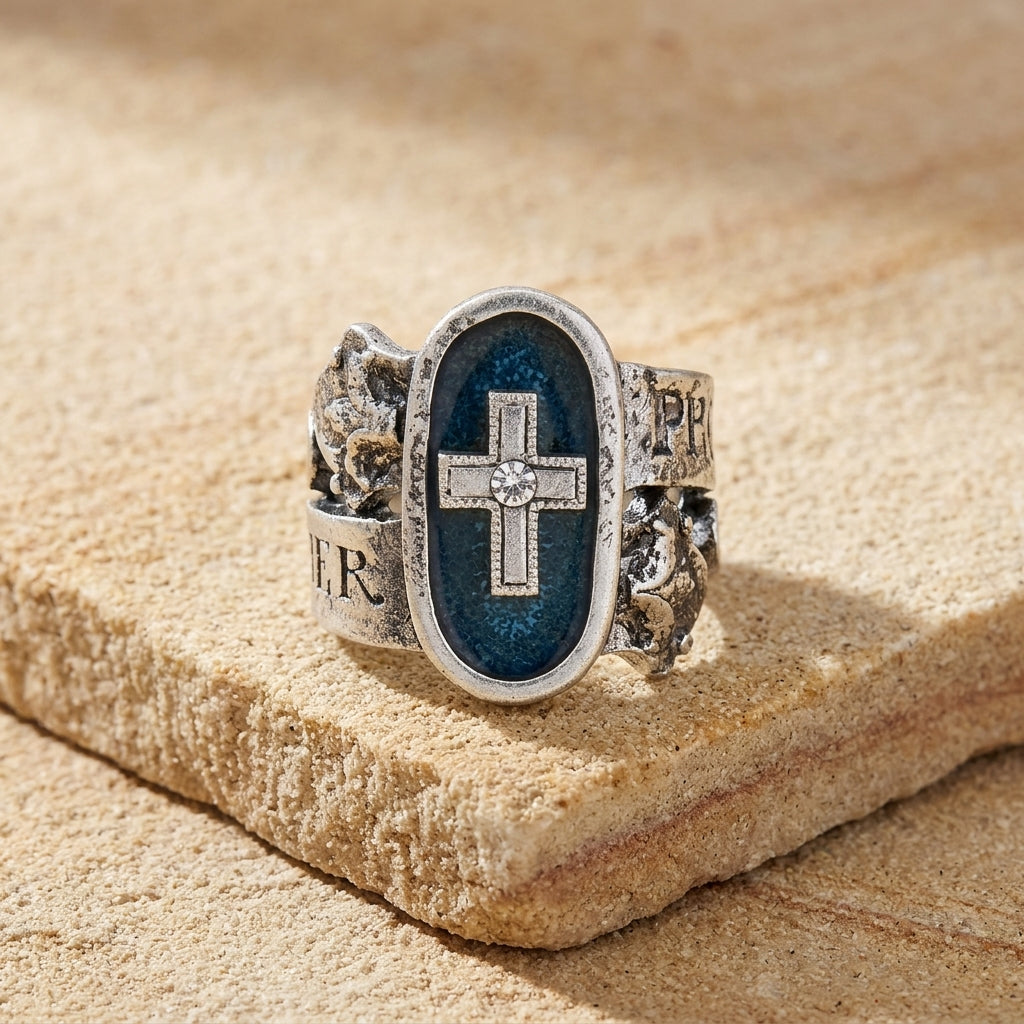 Silver cross ring with cross design on a textured stone surface