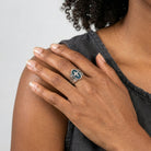 Hand with a cross ring on a plain background