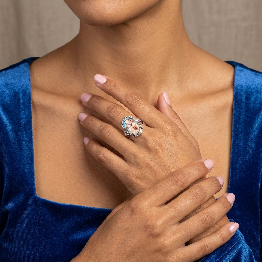 Close-up of a person wearing a Mother Mary and Child ring with a blue velvet garment