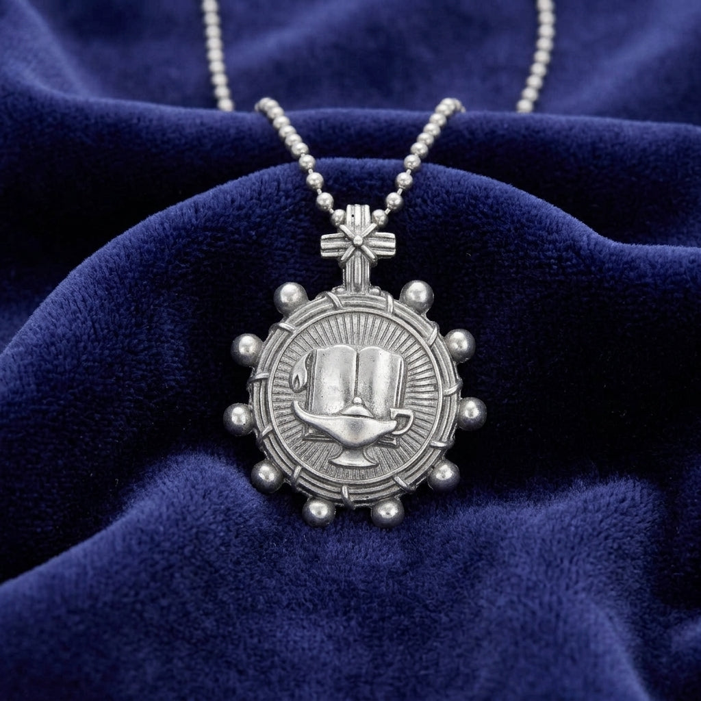 Silver necklace with a detailed bible rosary pendant on a blue velvet background