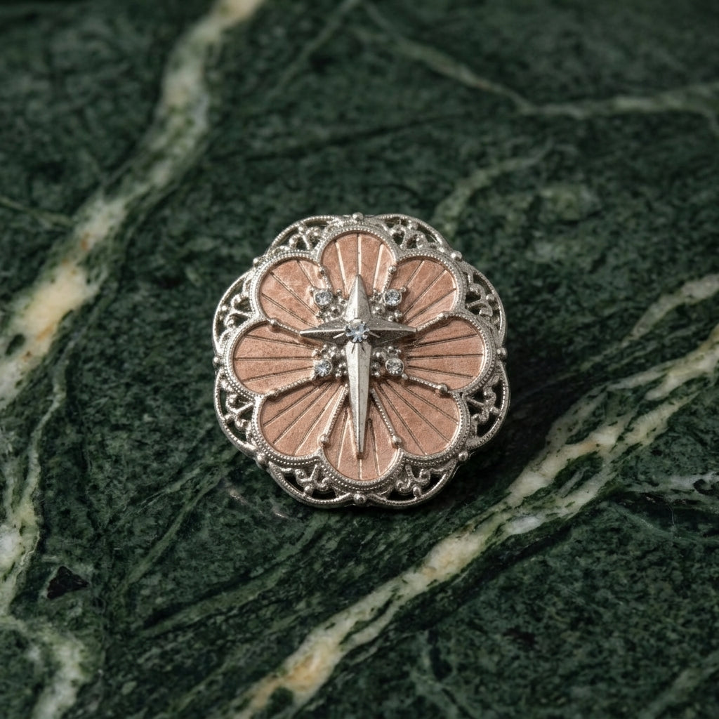 Decorative brooch with cross design on a green marble background