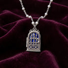 Necklace with a functional gate and cross locket on a dark purple fabric background