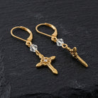Ornate Cross With Crystal & Lantern Bead Dangling Earrings on a dark stone background