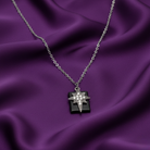 Necklace with a star-shaped cross pendant on a purple fabric background