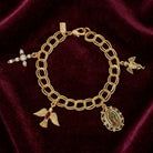 Gold bracelet with religious charms on a maroon velvet background