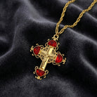 Gold cross pendant with red half moon crystals on a dark fabric background