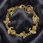 Gold bracelet with various religious and inspirational charms on a dark fabric background