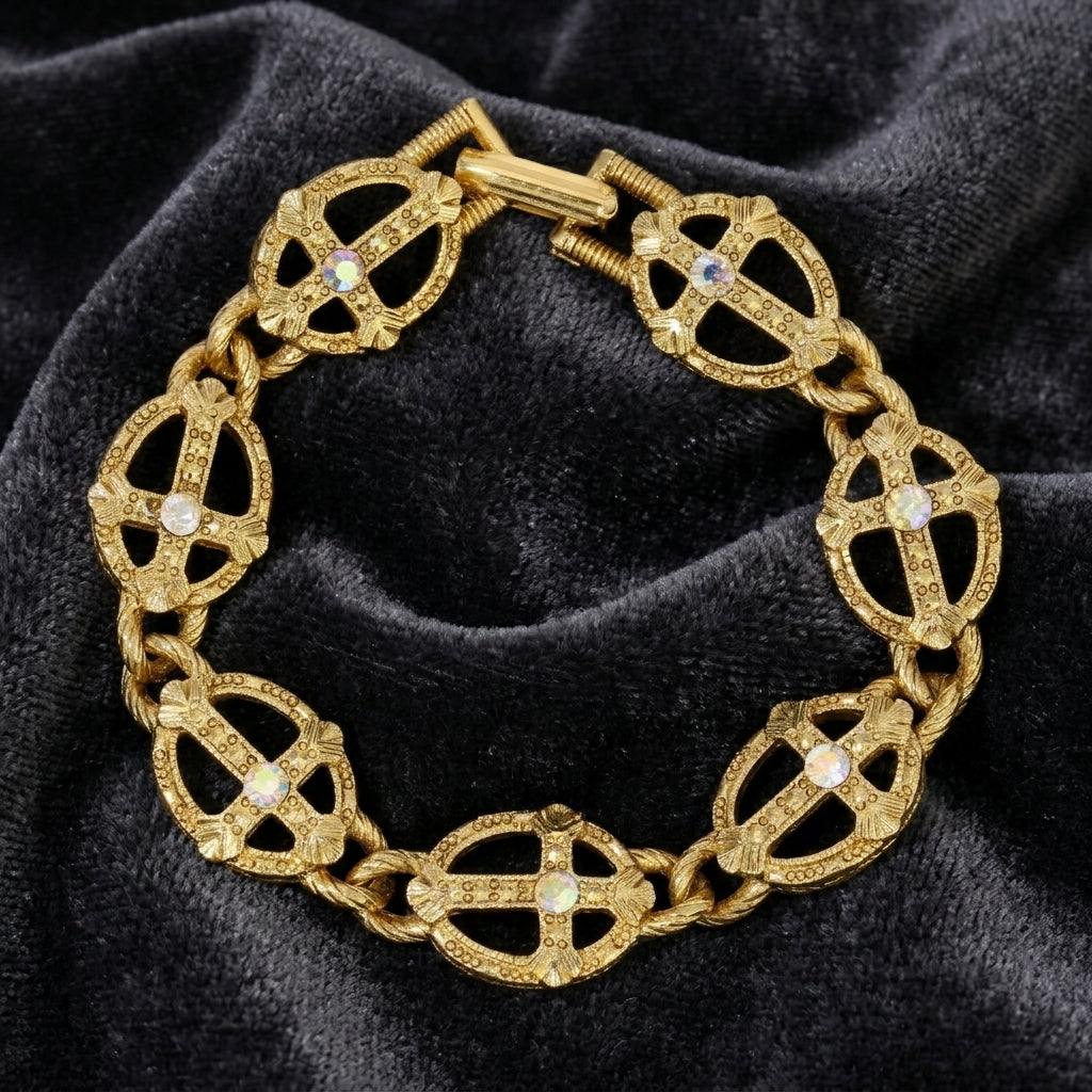 Gold bracelet with intricate design and AB crystals on a dark fabric background