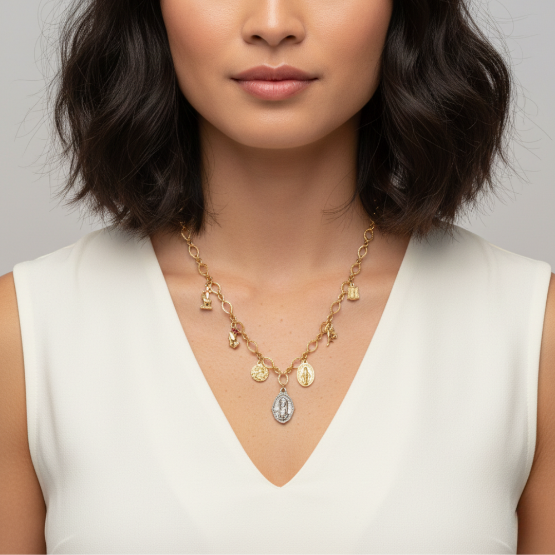 Woman wearing a gold necklace with various pendants against a neutral background