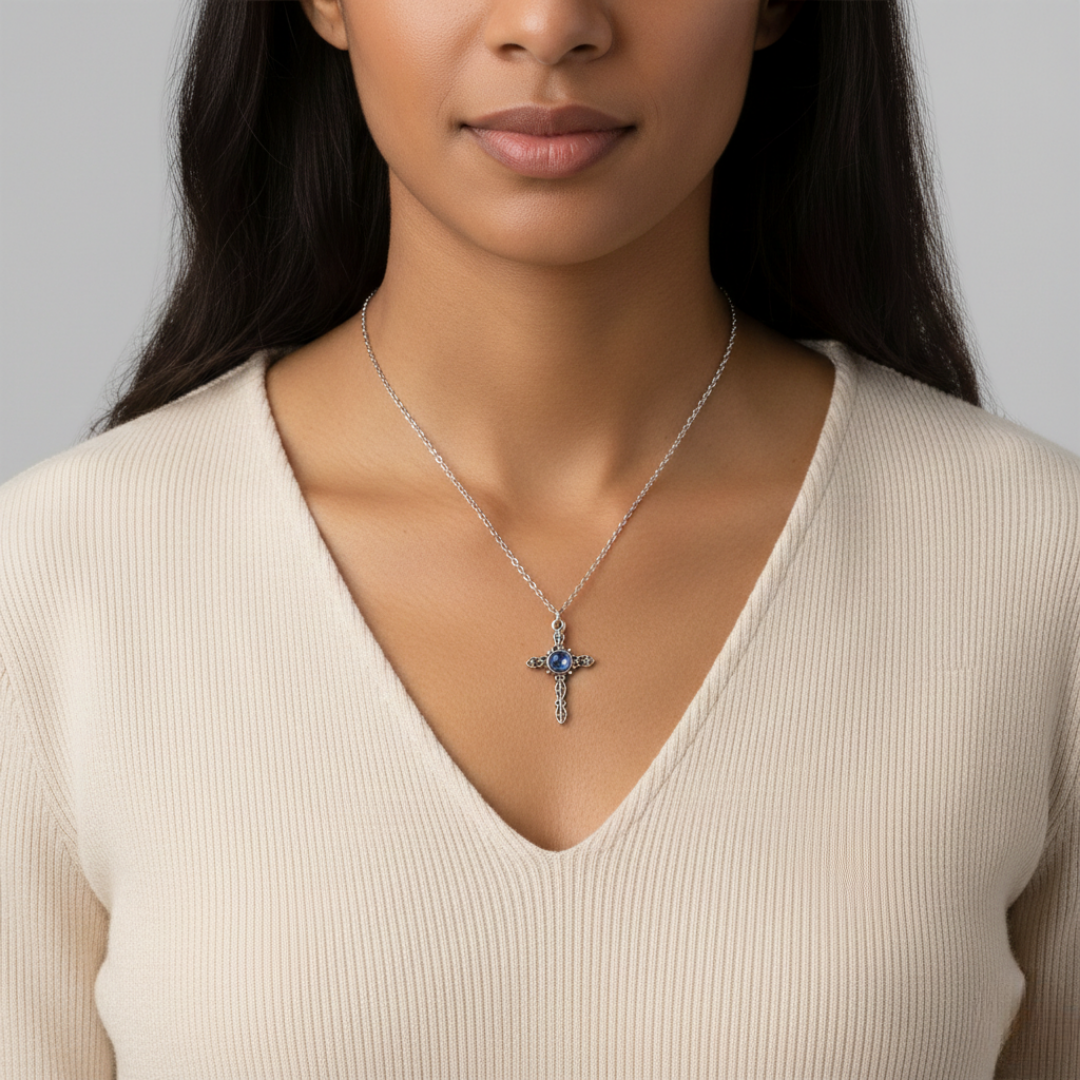 Woman wearing a necklace with a cross pendant on a plain background