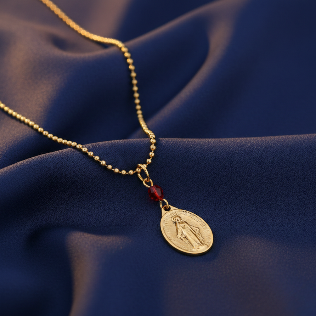 Gold necklace with a pendant on a blue fabric background