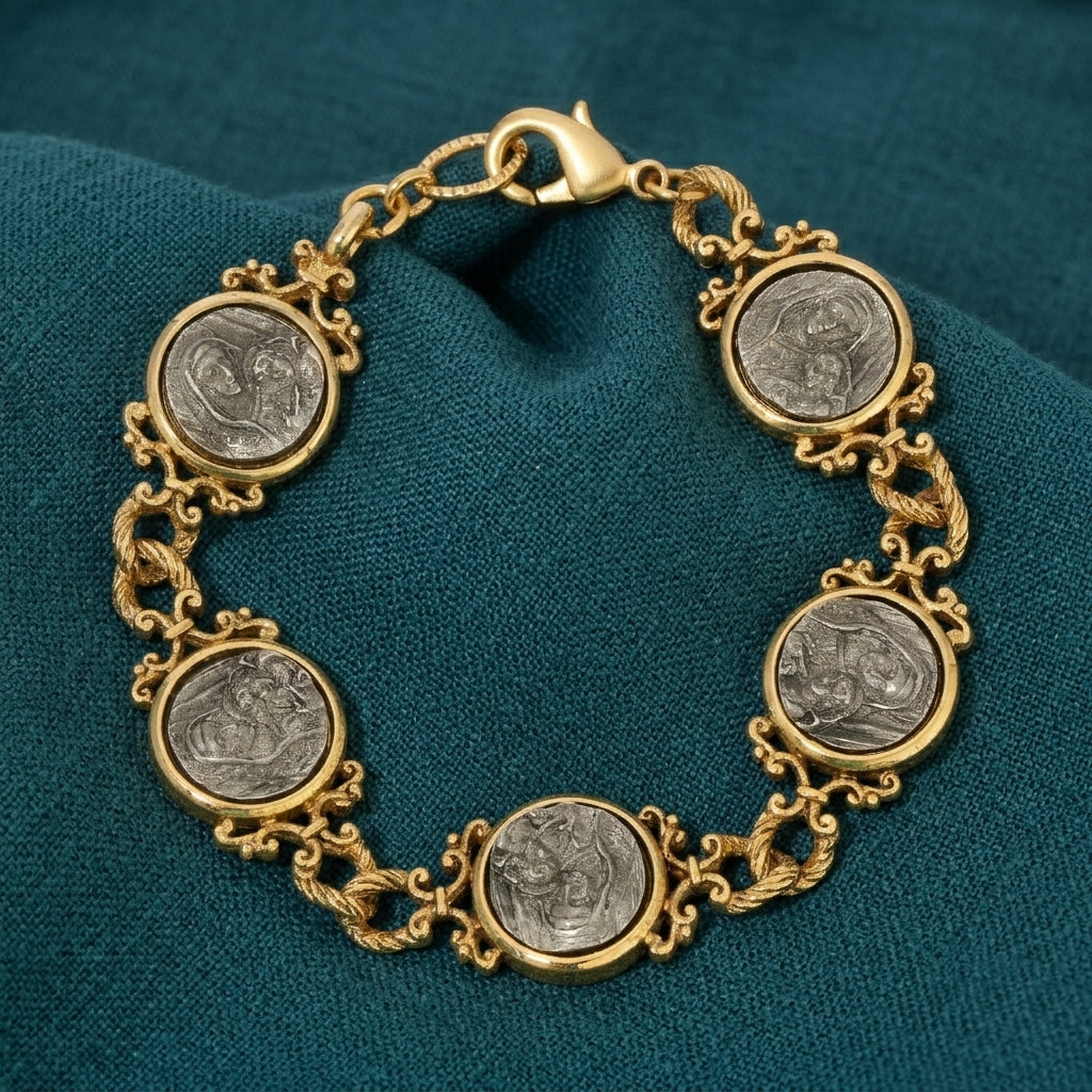 Gold tone bracelet with silver tone Mother Mary and Child design components on a teal fabric background
