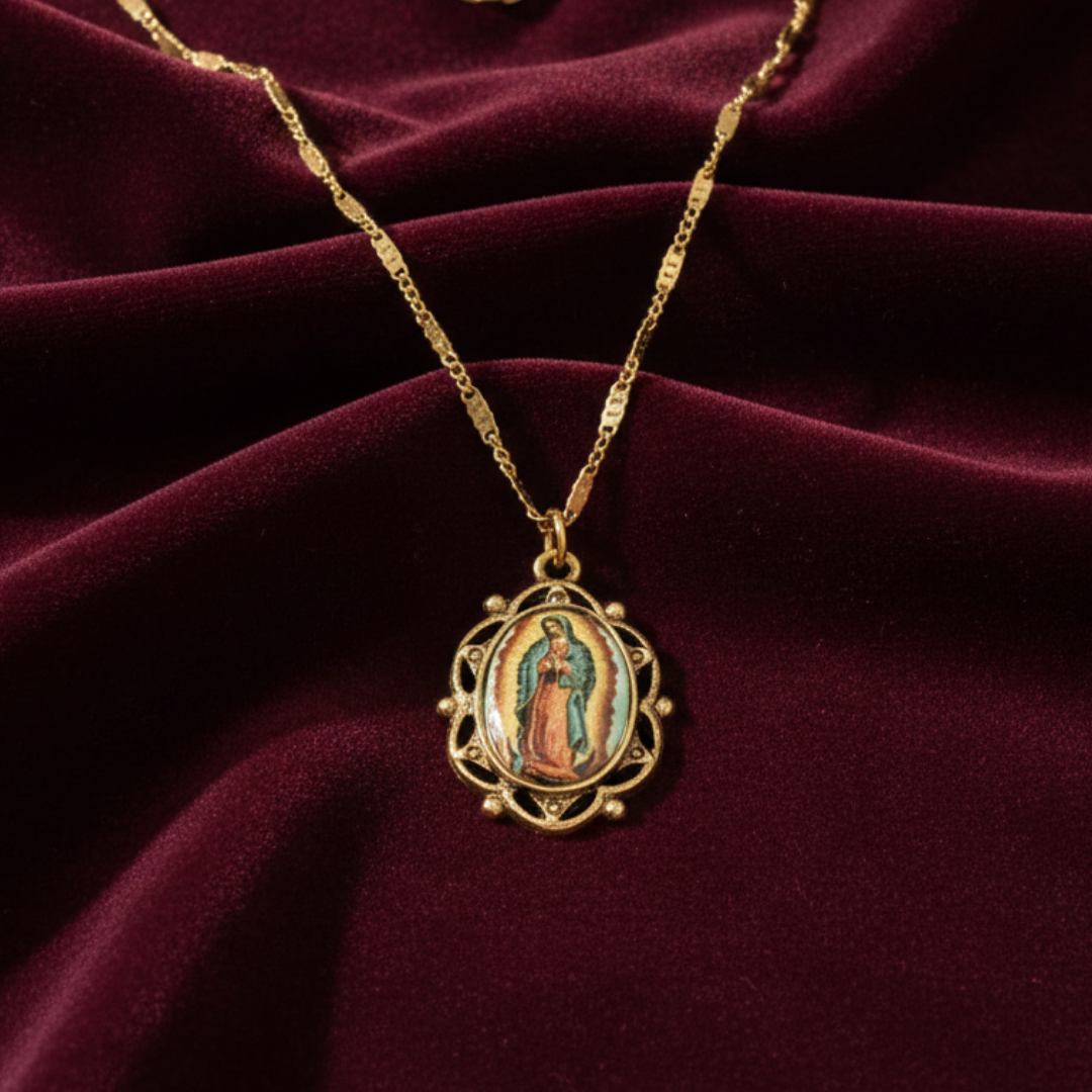 Gold necklace with a pendant featuring a religious figure on a maroon fabric background