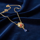 Gold necklace with a Jesus pendant on a blue fabric background