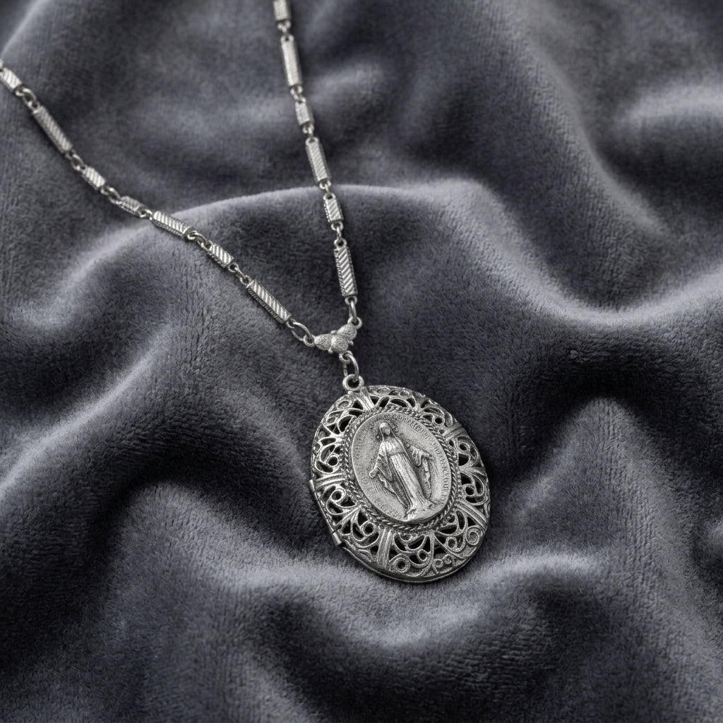 Silver necklace with a detailed Virgin Mary pendant on a textured gray fabric background