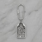 Silver keychain with religious design on a marble surface