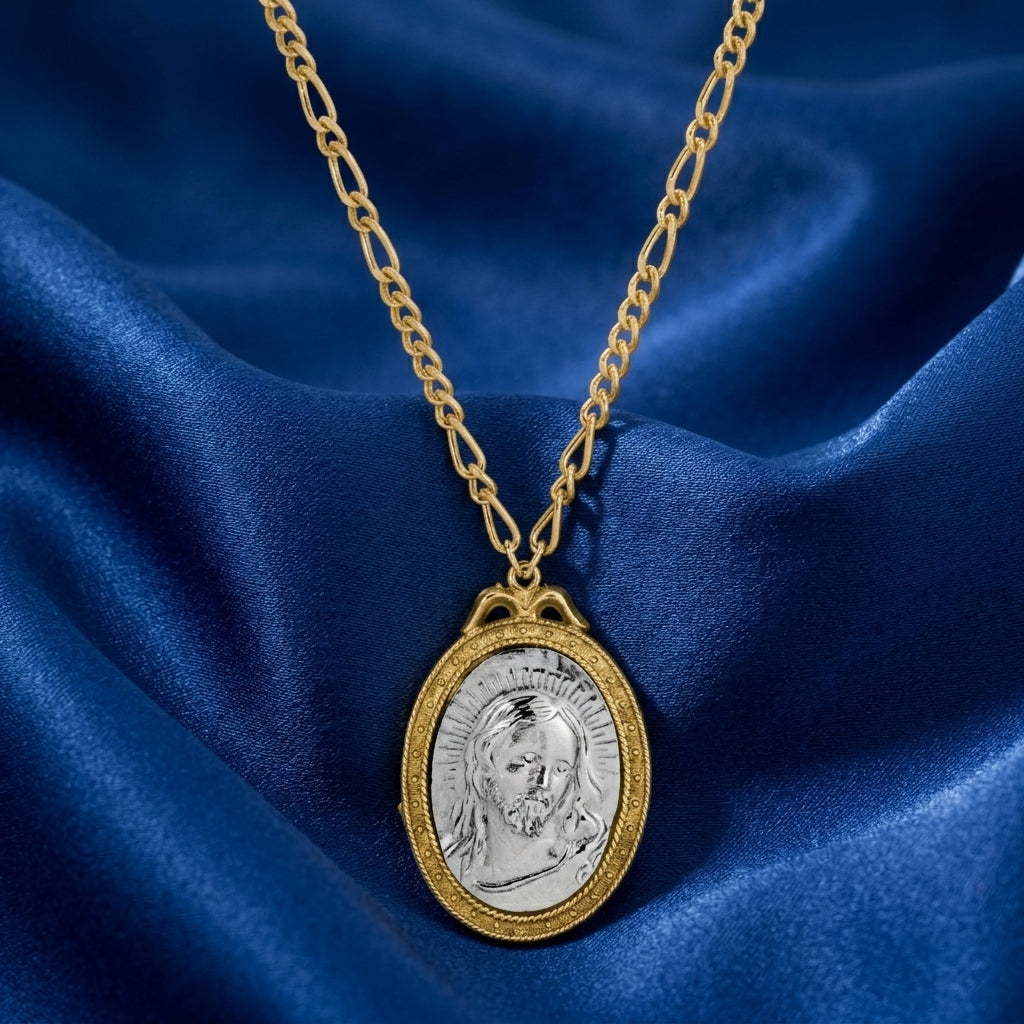 Gold necklace with a silver Jesus pendant on a blue fabric background
