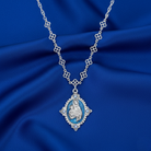 Silver necklace with a pendant on a blue fabric background