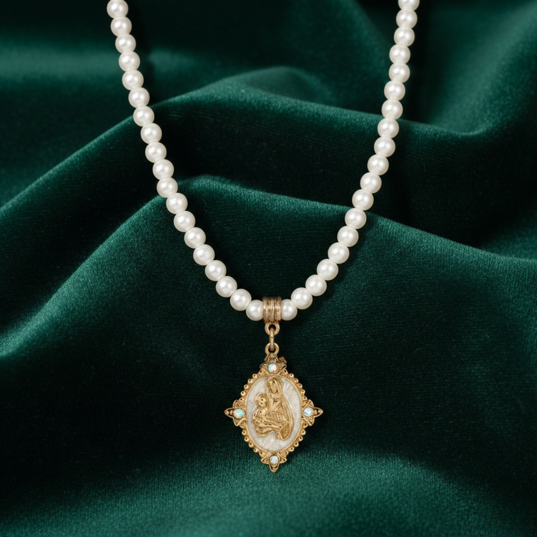 Pearl necklace with a gold pendant on a green fabric background
