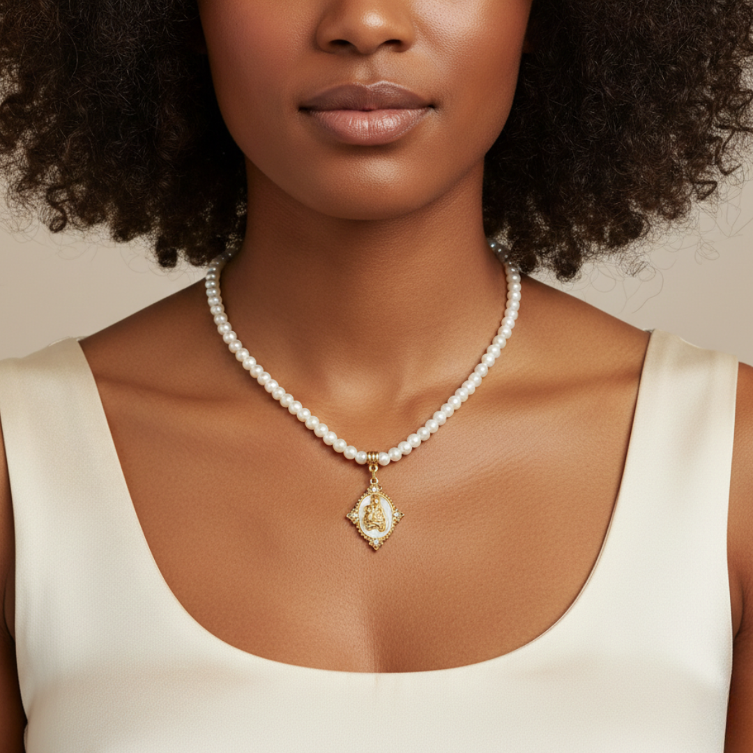Woman wearing a pearl necklace with a gold pendant against a neutral background