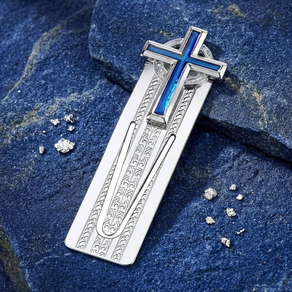 Silver cross bookmark with blue enamel on a textured blue stone surface