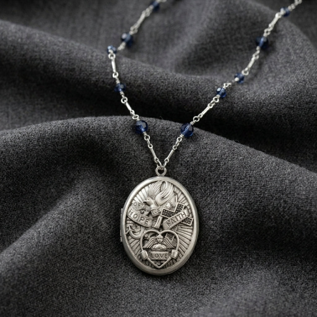 Silver locket necklace with blue beads on a dark fabric background
