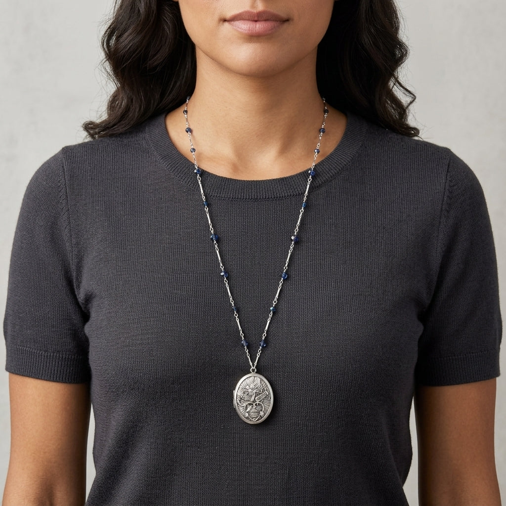 Woman wearing a long silver necklace with blue beads and a religious pendant 