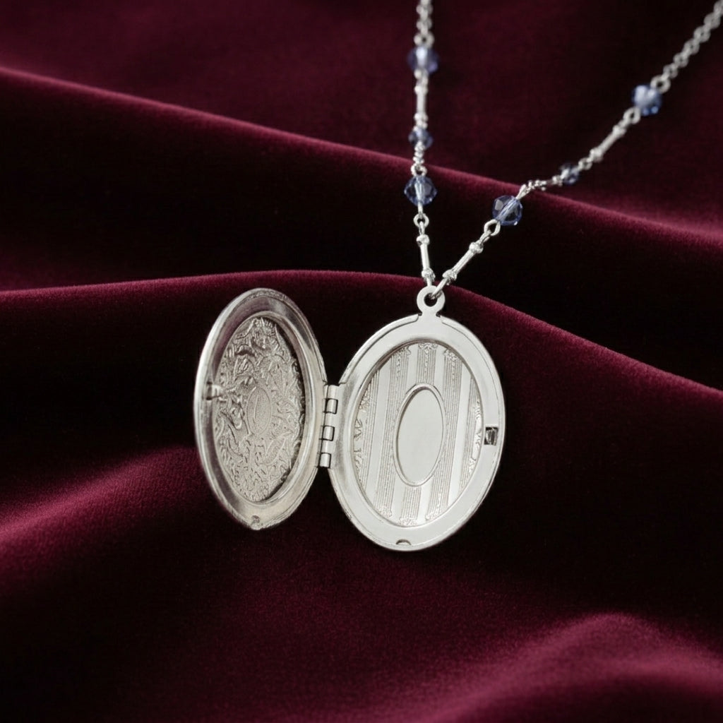 Silver open locket necklace on a burgundy fabric background