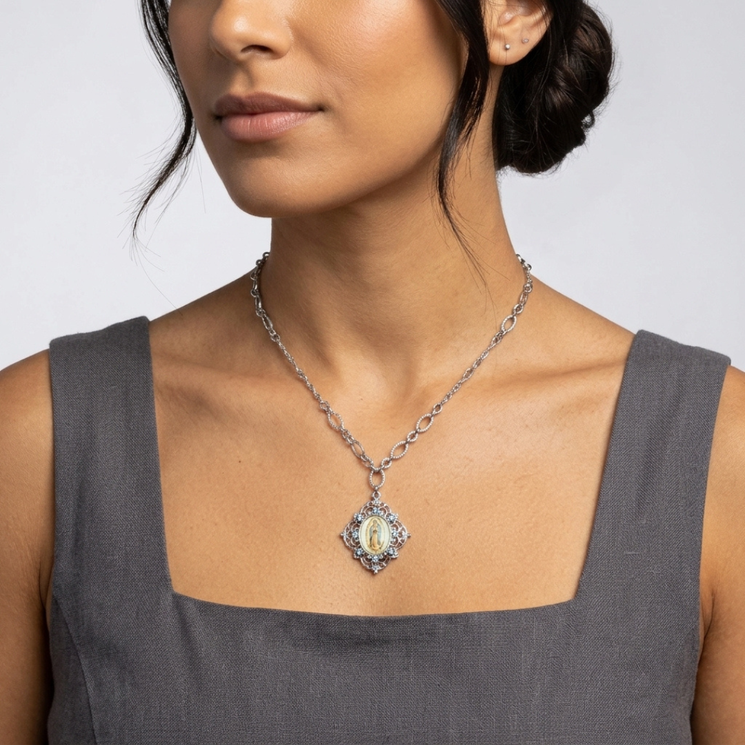 Woman wearing a necklace with a religious pendant against a neutral background