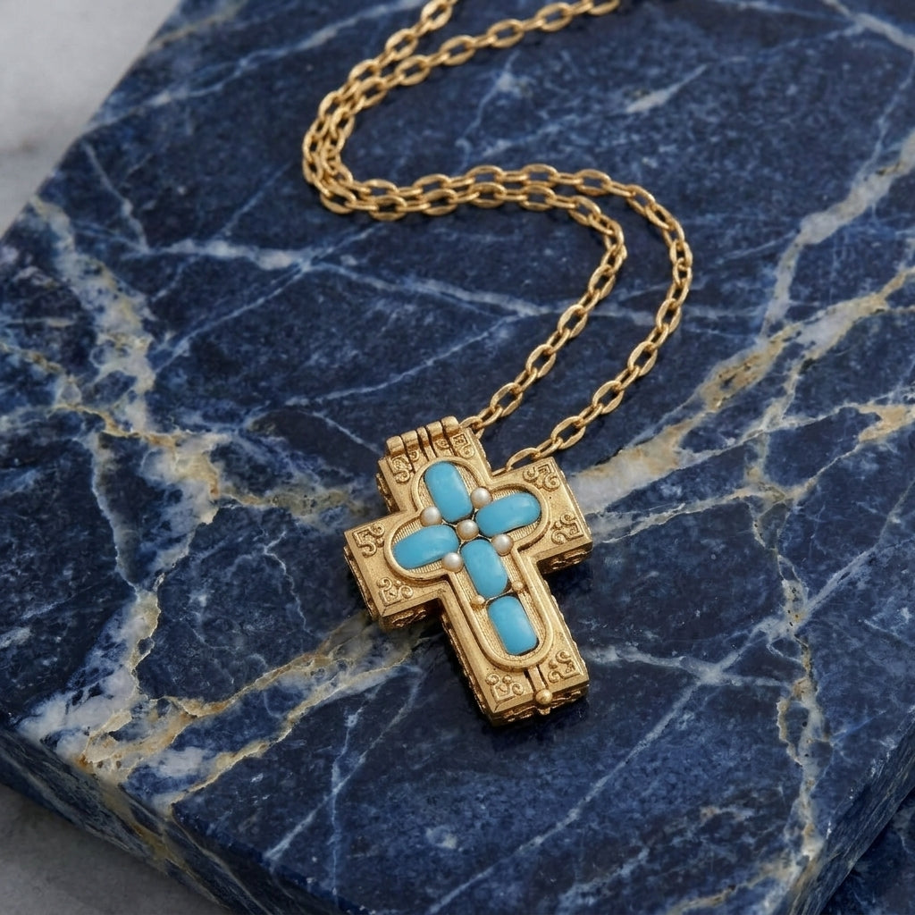 Gold cross necklace with turquoise stone on a blue marble surface